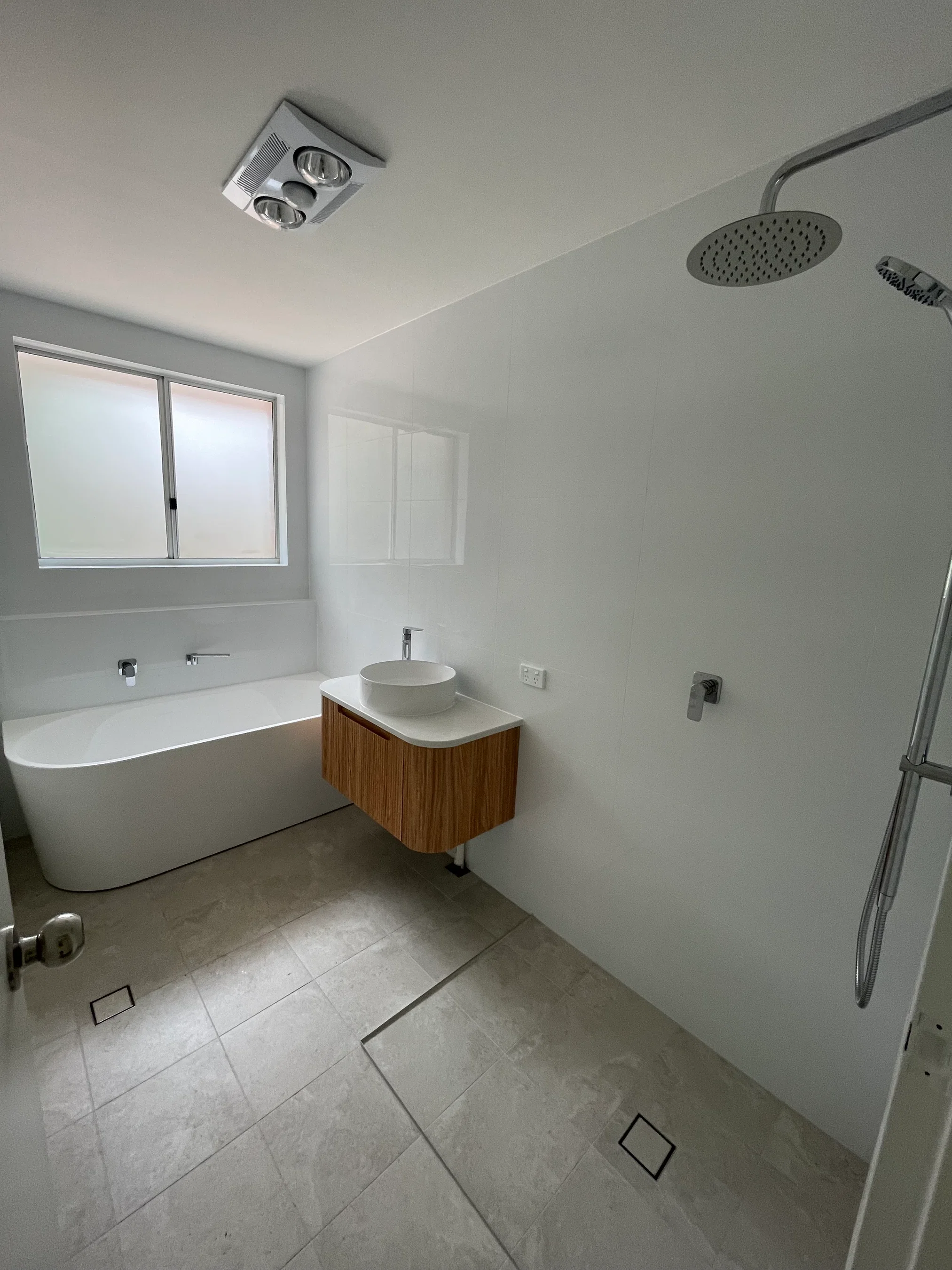 Bright bathroom with freestanding bath, floating vanity and walk-in shower